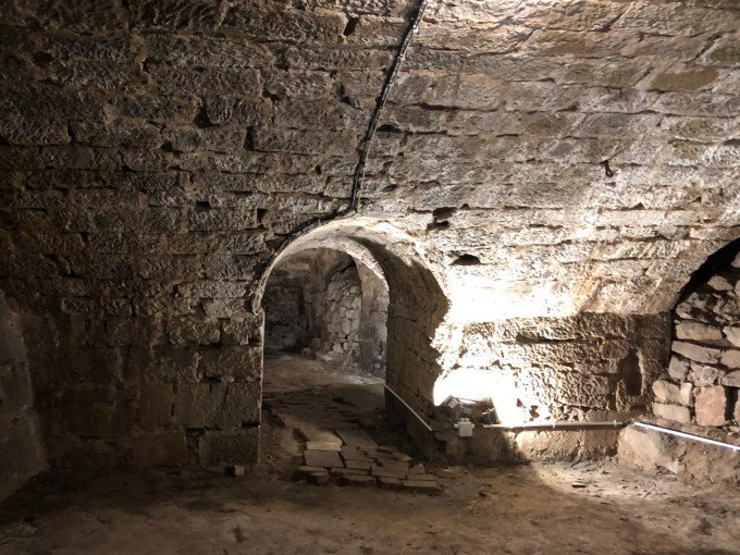 Ein steinerner Gew&ouml;lbekeller mit einem beleuchteten Durchgang. Die W&auml;nde und Decke bestehen aus grobem Mauerwerk., &copy; Eigenbetrieb Tourismus und Citymanagement Schorndorf
