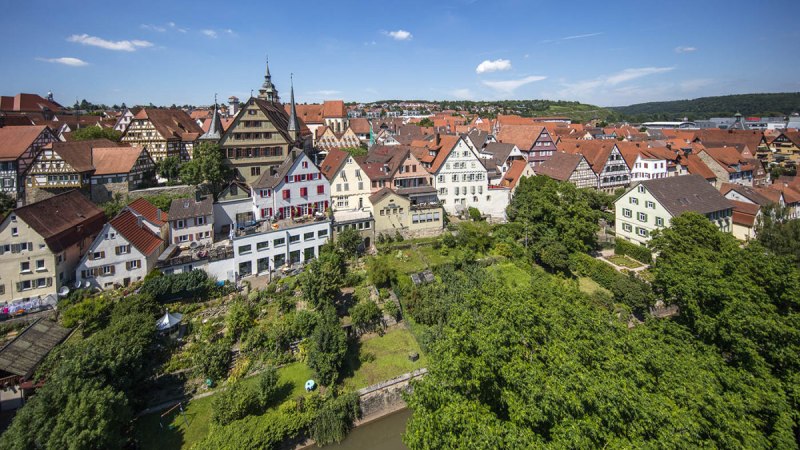 Luftaufnahme der Bietigheimer Altstadt mit Fachwerkhäusern, roten Dächern und grünen Gärten unter blauem Himmel., © 3B-Tourismus