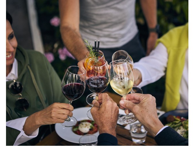 Eine Gruppe von Menschen stößt mit Weingläsern und einem Cocktail an einem gedeckten Tisch an., © Esslinger Stadtmarketing &amp; Tourismus GmbH