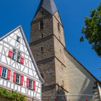 Fachwerkhaus mit roten Fensterläden neben der Alexanderkirche in Marbach am Neckar, umgeben von Bäumen und blauem Himmel., © SMG Achim Mende