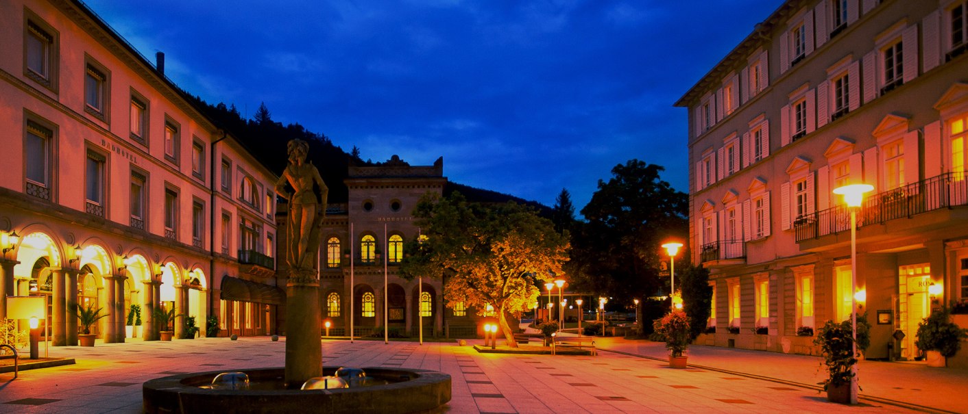 Ein beleuchteter Platz bei Nacht mit historischen Geb&auml;uden und einer Statue im Vordergrund. Die warmen Lichter schaffen eine einladende Atmosph&auml;re., &copy; Mokni's Palais Hotel & Spa