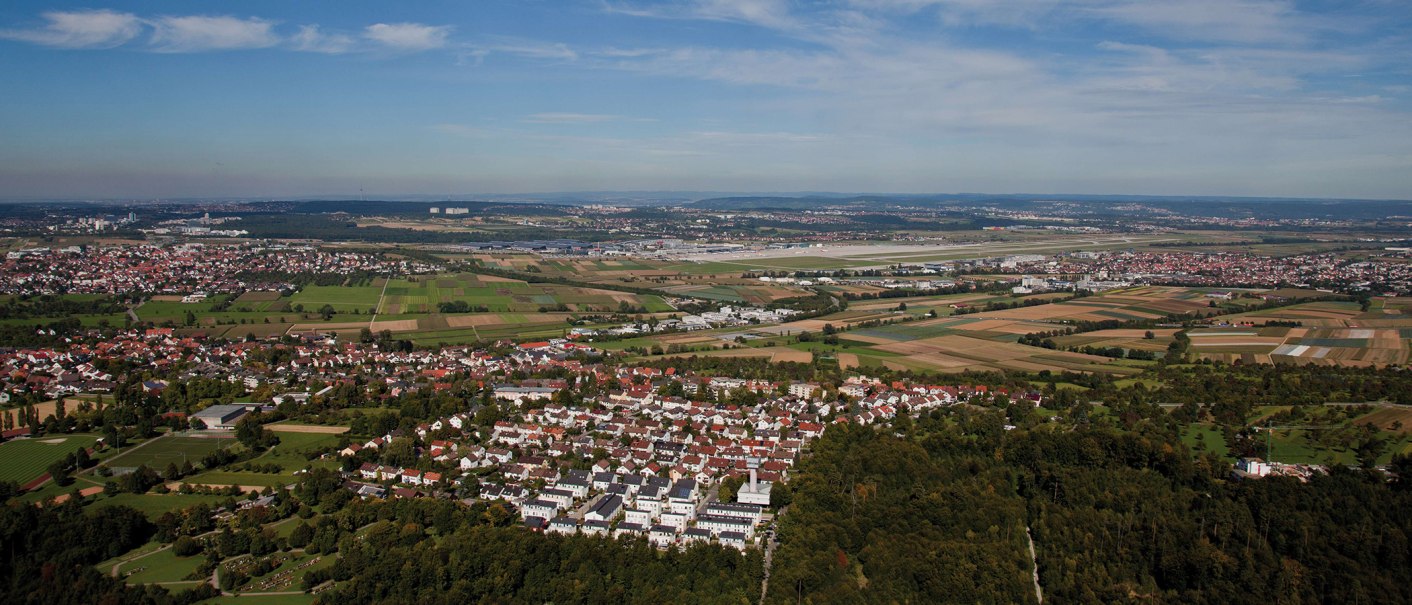 Luftaufnahme von Leinfelden-Echterdingen: Wohngebiete, Felder und ein Flughafen im Hintergrund unter blauem Himmel., © Stuttgart-Marketing GmbH