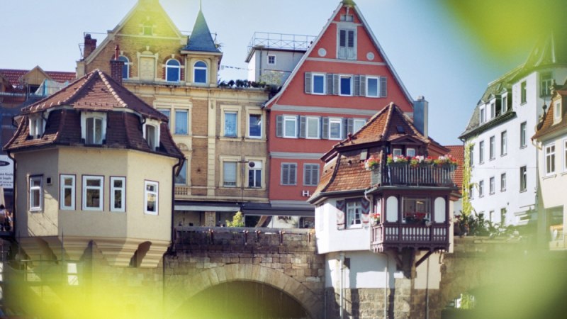 Historische Gebäude auf der Inneren Brücke in Esslingen mit Fachwerk und Erkern, umgeben von grünen Blättern im Vordergrund., © Esslinger Stadtmarketing & Tourismus GmbH Historische Gebäude auf der Inneren Brücke in Esslingen mit Fachwerk und Erkern, umgeben von grünen Blättern im Vordergrund., © Esslinger Stadtmarketing & Tourismus GmbH