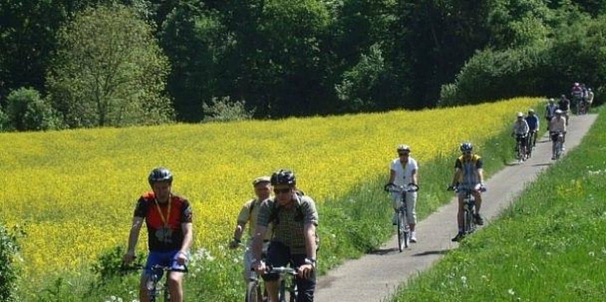 Radfahrer auf einem schmalen Weg neben einem gelben Rapsfeld, umgeben von grüner Natur., © Natur.Nah. Schönbuch & Heckengäu Radfahrer auf einem schmalen Weg neben einem gelben Rapsfeld, umgeben von grüner Natur., © Natur.Nah. Schönbuch & Heckengäu