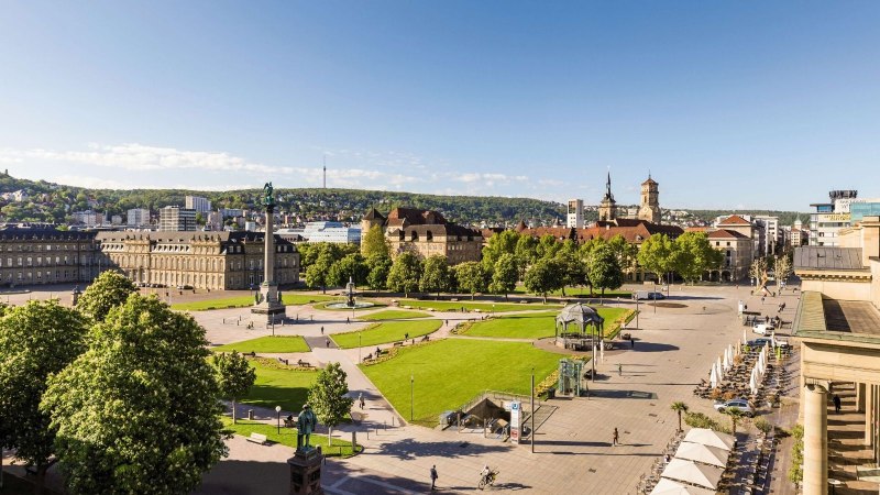 Panoramablick auf den Schlossplatz in Stuttgart mit Gr&uuml;nfl&auml;chen, historischen Geb&auml;uden und einem klaren blauen Himmel., &copy; Stuttgart-Marketing GmbH Werner Dieterich