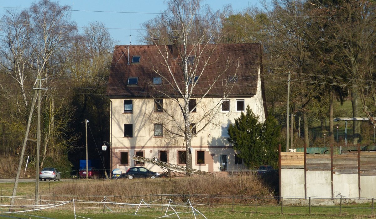 Mehrstöckiges Gebäude mit braunem Dach, umgeben von Bäumen und Wiesen, unter blauem Himmel., © Natur.Nah. Schönbuch & Heckengäu