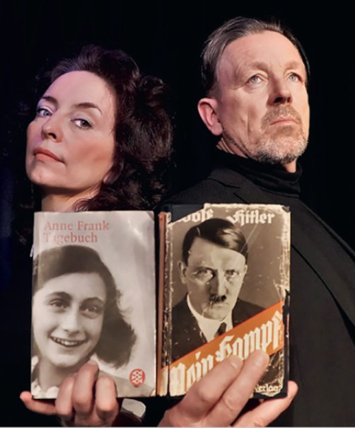Zwei Personen posieren mit ernsten Gesichtern und halten Bücher von Anne Frank und Adolf Hitler in den Händen., © Theaterwerkstatt Schwäbisch Gmünd e.V. Zwei Personen posieren mit ernsten Gesichtern und halten Bücher von Anne Frank und Adolf Hitler in den Händen., © Theaterwerkstatt Schwäbisch Gmünd e.V.