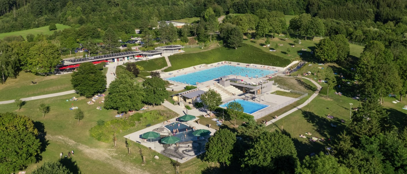 mehrere Schwimmbecken inmitten großzügiger, baumbestandener Liegewiese, © Stadt Gaildorf