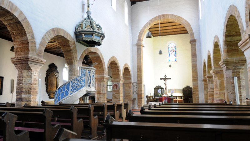 Innenansicht der Evangelischen Stiftskirche Bad Boll mit Holzbänken, einer verzierten Kanzel und einem Altar mit Kreuz., © Landkreis Göppingen Innenansicht der Evangelischen Stiftskirche Bad Boll mit Holzbänken, einer verzierten Kanzel und einem Altar mit Kreuz., © Landkreis Göppingen