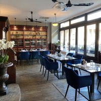 Elegantes Restaurant mit blauen St&uuml;hlen, Holzboden und gro&szlig;en Fenstern. Orchideen und eine Vitrine mit Flaschen schm&uuml;cken den Raum., &copy; Steigenberger Hotels GmbH