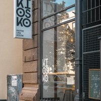 Ein Kiosk mit der Aufschrift 'Kiosko Kaffee und Kiosk'. Die Fassade ist mit Graffiti bedeckt, und das Schaufenster spiegelt die Umgebung wider., © SMG, Sarah Schmid Ein Kiosk mit der Aufschrift 'Kiosko Kaffee und Kiosk'. Die Fassade ist mit Graffiti bedeckt, und das Schaufenster spiegelt die Umgebung wider., © SMG, Sarah Schmid