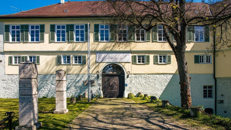 Das Schlossmuseum in Kirchheim unter Teck zeigt ein historisches Geb&auml;ude mit gr&uuml;nen Fensterl&auml;den und Gedenksteinen im Vordergrund, umgeben von einem gepflegten Garten., &copy; Stuttgart-Marketing GmbH, Sarah Schmid