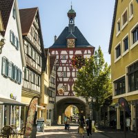 Historisches Stadttor in Bietigheim-Bissingen mit Fachwerk und Uhr, umgeben von alten Gebäuden und Geschäften., © Stuttgart Marketing GmbH, Sarah Schmid