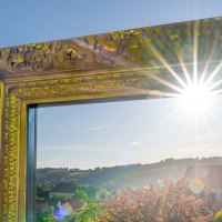 Ein großer, verzierter goldener Bilderrahmen mit Sonnenstrahlen, der einen Blick auf Schwäbisch Gmünd und die umliegende Landschaft bietet., © SMG, Martina Denker