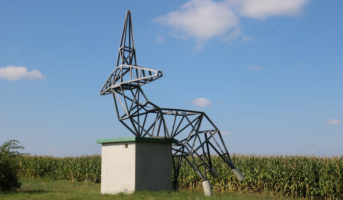 Metallskulptur eines stilisierten Rehs auf einem Betonsockel vor einem Maisfeld und blauem Himmel., © Remstal Tourismus e.V. Metallskulptur eines stilisierten Rehs auf einem Betonsockel vor einem Maisfeld und blauem Himmel., © Remstal Tourismus e.V.