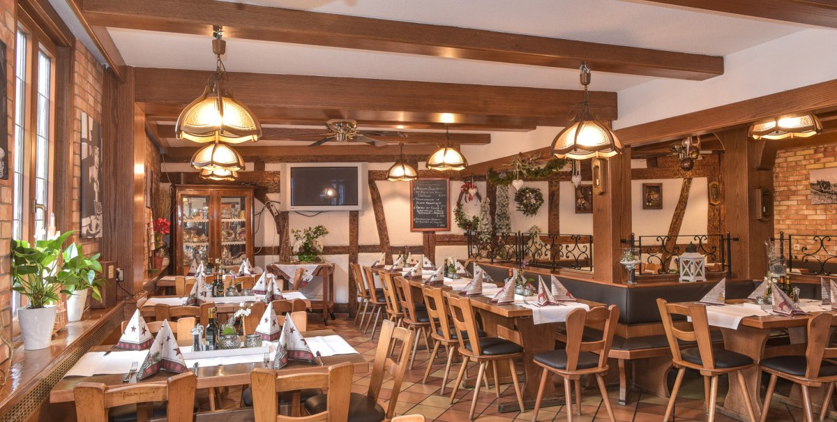 Ein gemütliches Restaurant mit Holzmöbeln, dekorierten Tischen und warmem Licht. Pflanzen und Dekorationen verleihen dem Raum eine einladende Atmosphäre. Ein gemütliches Restaurant mit Holzmöbeln, dekorierten Tischen und warmem Licht. Pflanzen und Dekorationen verleihen dem Raum eine einladende Atmosphäre.