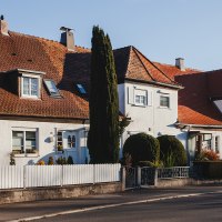 Reihenhäuser mit roten Ziegeldächern und weißen Fassaden in einer ruhigen Wohnsiedlung bei Sonnenschein., © benjaminknoblauch.de Reihenhäuser mit roten Ziegeldächern und weißen Fassaden in einer ruhigen Wohnsiedlung bei Sonnenschein., © benjaminknoblauch.de