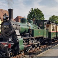 Eine gr&uuml;ne historische Dampflokomotive steht auf einem Gleis in N&uuml;rtingen. Der Himmel ist leicht bew&ouml;lkt, und im Hintergrund sind B&auml;ume und H&auml;user zu sehen., &copy; StadtN&uuml;rtingen