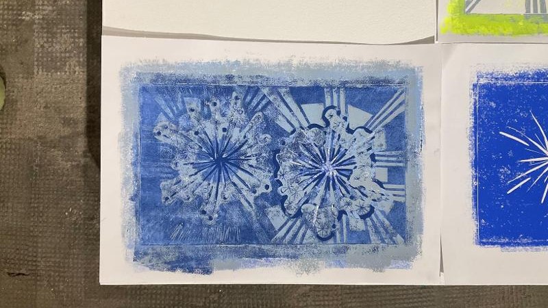 Ein blaues Druckkunstwerk zeigt abstrakte Muster auf weißem Papier. Es wirkt kreativ und detailreich gestaltet., © Kunstschule Labyrinth Ein blaues Druckkunstwerk zeigt abstrakte Muster auf weißem Papier. Es wirkt kreativ und detailreich gestaltet., © Kunstschule Labyrinth