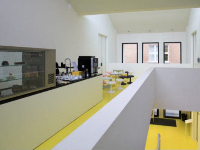 Modernes Caf&eacute; mit gelbem Boden, wei&szlig;en W&auml;nden und minimalistischen M&ouml;beln. Gro&szlig;e Fenster lassen viel Licht herein., &copy; Kunsthalle G&ouml;ppingen