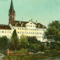 weiß gestrichenes, langgezogenes, mehrstöckiges Schlossgebäude, hinter Bäumen am Kocherufer, im Hintergrund Turm und Kichenschiff der evangelischen Stadtkirche, © Stadtarchiv Gaildorf