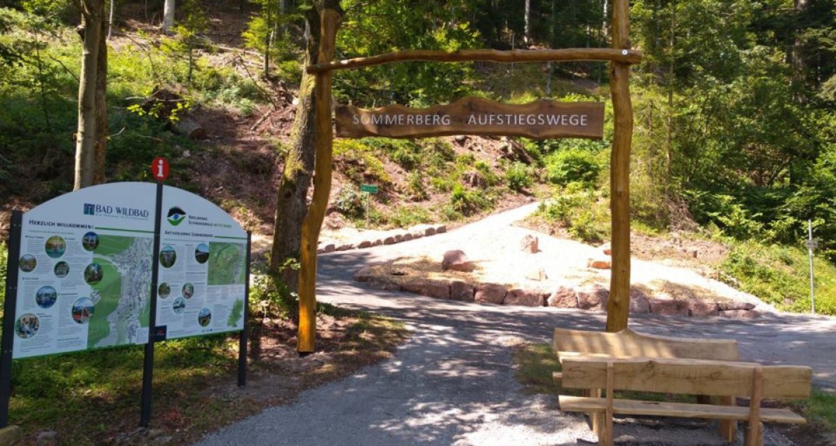 Holzportal mit Schild 'Sommerberg Aufstiegswege', Infotafel und Bank im Wald von Bad Wildbad., © Nördlicher Schwarzwald Holzportal mit Schild 'Sommerberg Aufstiegswege', Infotafel und Bank im Wald von Bad Wildbad., © Nördlicher Schwarzwald