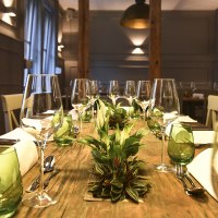 Ein stilvoll gedeckter Esstisch mit Weingl&auml;sern, gr&uuml;nen Gl&auml;sern und Pflanzen als Dekoration in einem eleganten Raum., &copy; Classic Rock Caf&eacute; Gastronomie- Betriebs GmbH