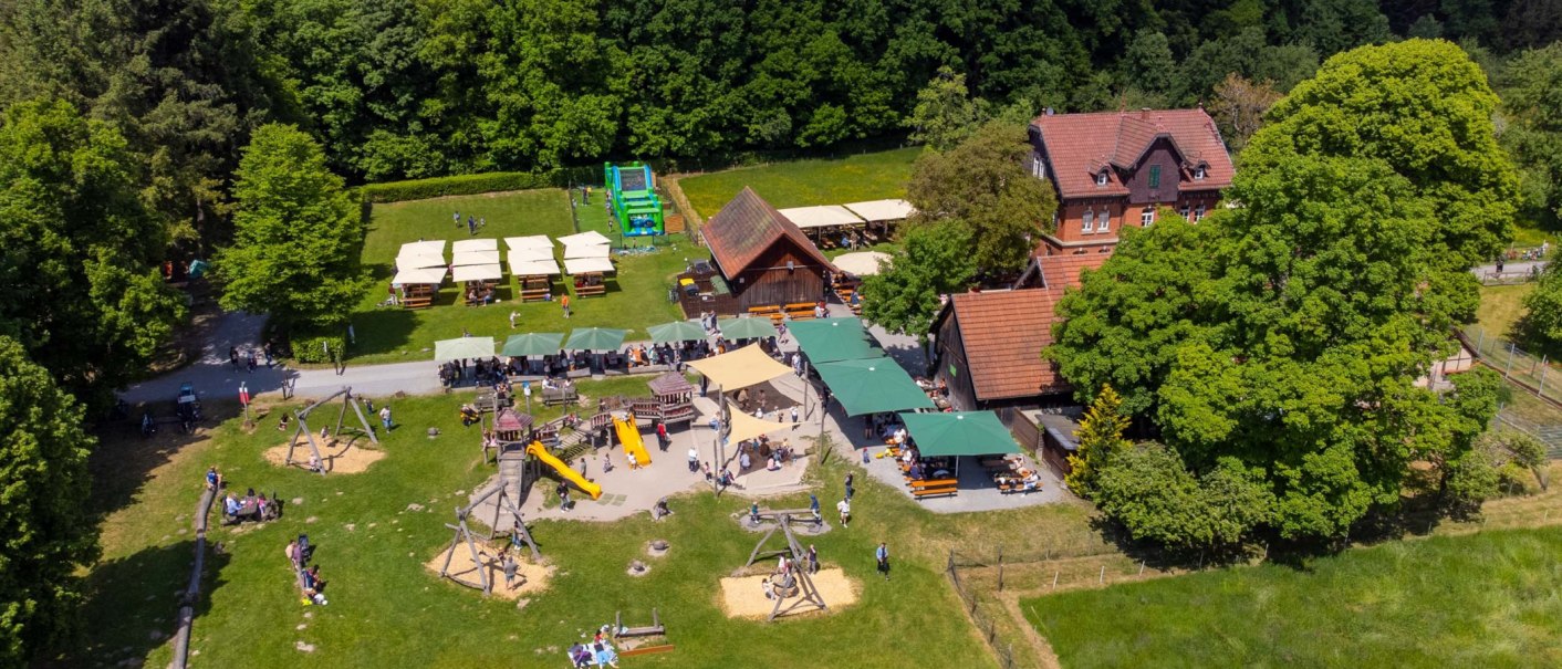 Luftaufnahme des Katzenbacher Hofs mit Spielplatz, Biergarten und grüner Umgebung. Menschen genießen das sonnige Wetter im Freien., © Katzenbacher Hof Luftaufnahme des Katzenbacher Hofs mit Spielplatz, Biergarten und grüner Umgebung. Menschen genießen das sonnige Wetter im Freien., © Katzenbacher Hof