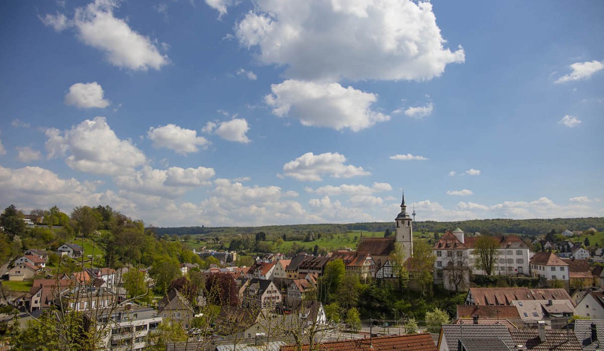 Panoramablick über Waldenbuch mit Kirche, Fachwerkhäusern und grüner Landschaft unter blauem Himmel mit Wolken., © Natur.Nah. Schönbuch & Heckengäu Panoramablick über Waldenbuch mit Kirche, Fachwerkhäusern und grüner Landschaft unter blauem Himmel mit Wolken., © Natur.Nah. Schönbuch & Heckengäu