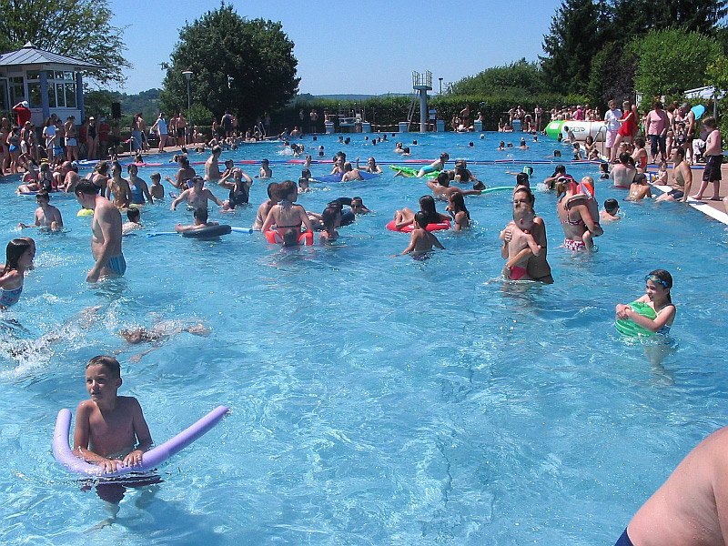 Viele Menschen genießen einen sonnigen Tag im Freibad Renningen. Kinder und Erwachsene schwimmen und spielen im Wasser., © Stadt Renningen