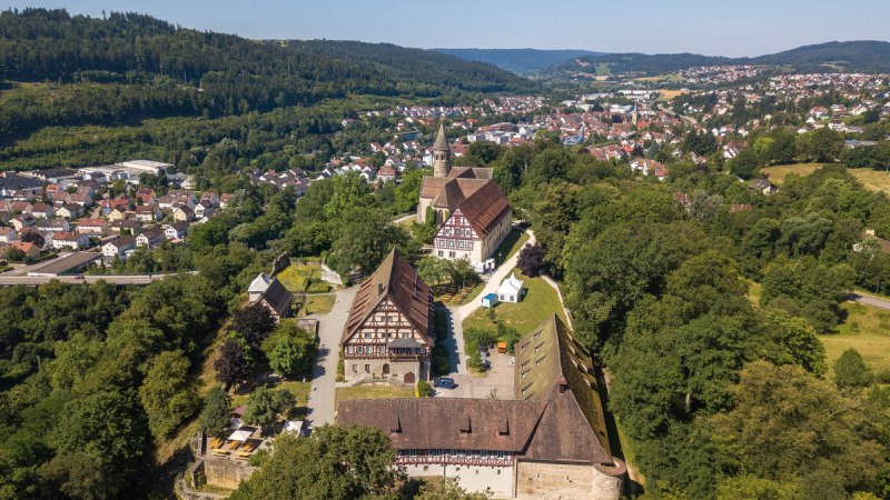 Luftaufnahme des Klosters Lorch, umgeben von Bäumen und einer kleinen Stadt im Hintergrund. Historische Gebäude und eine Kirche sind sichtbar., © Remstal Tourismus e.V. Luftaufnahme des Klosters Lorch, umgeben von Bäumen und einer kleinen Stadt im Hintergrund. Historische Gebäude und eine Kirche sind sichtbar., © Remstal Tourismus e.V.