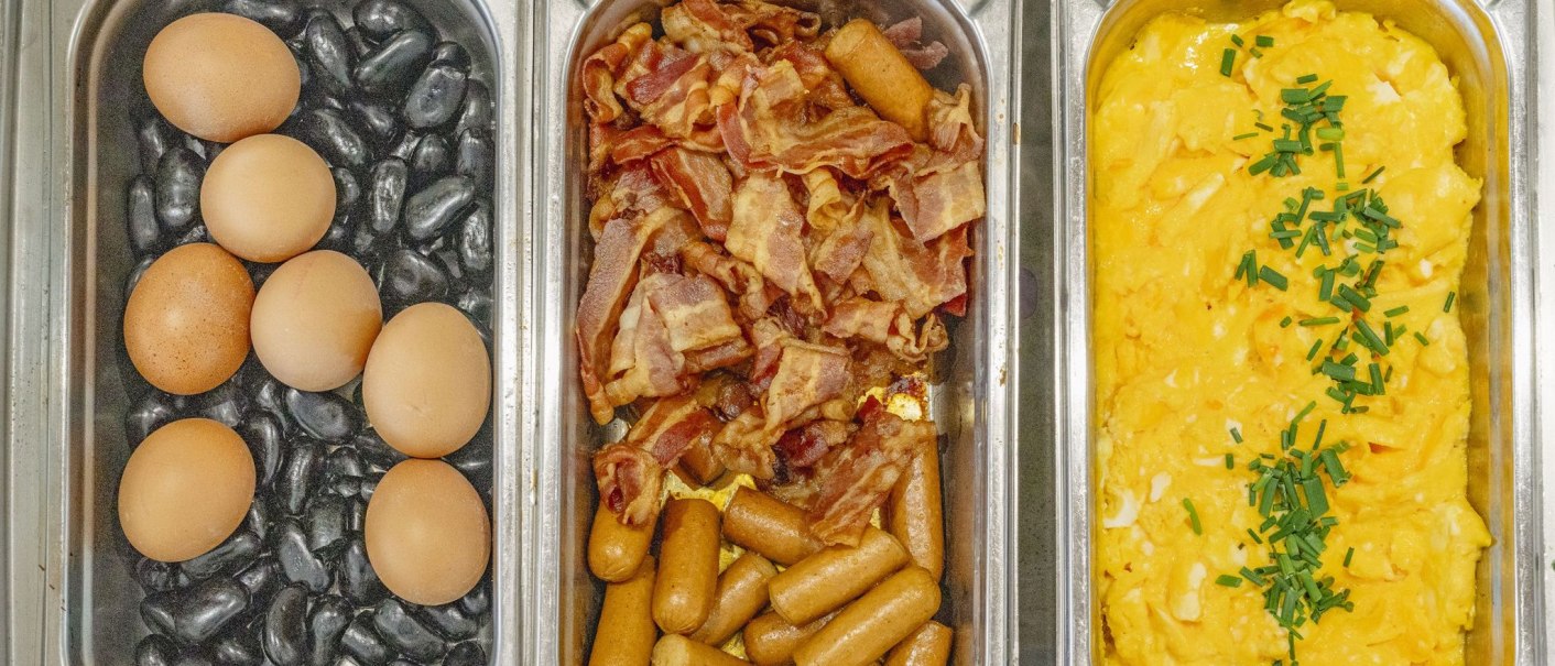 Drei Behälter mit Frühstückszutaten: Eier auf Steinen, Speck und Würstchen, Rührei mit Schnittlauch., © Plaza INN Stuttgart-Filderstadt Drei Behälter mit Frühstückszutaten: Eier auf Steinen, Speck und Würstchen, Rührei mit Schnittlauch., © Plaza INN Stuttgart-Filderstadt