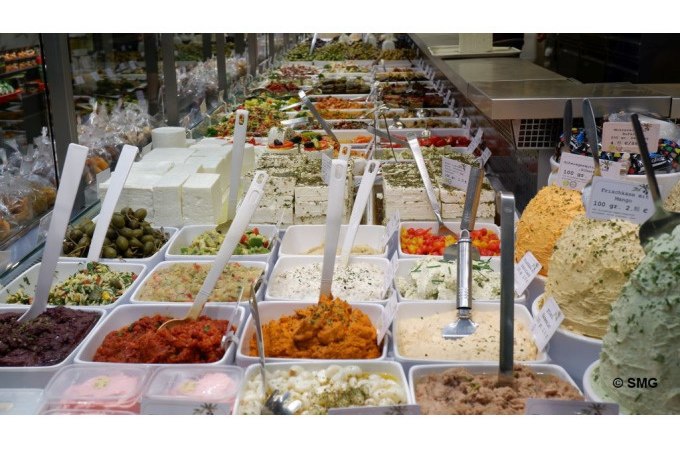 Verschiedene Dips und Aufstriche in einer Markthalle. Bunte Vielfalt in weißen Behältern, darunter Oliven, Käse und Kräuter., © Stuttgart Marketing GmbH Verschiedene Dips und Aufstriche in einer Markthalle. Bunte Vielfalt in weißen Behältern, darunter Oliven, Käse und Kräuter., © Stuttgart Marketing GmbH