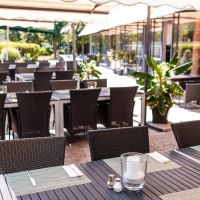 Restaurantterrasse mit gedeckten Tischen und Stühlen unter Sonnenschirmen, umgeben von Pflanzen., © PLAZA Hotelgroup GmbH Restaurantterrasse mit gedeckten Tischen und Stühlen unter Sonnenschirmen, umgeben von Pflanzen., © PLAZA Hotelgroup GmbH