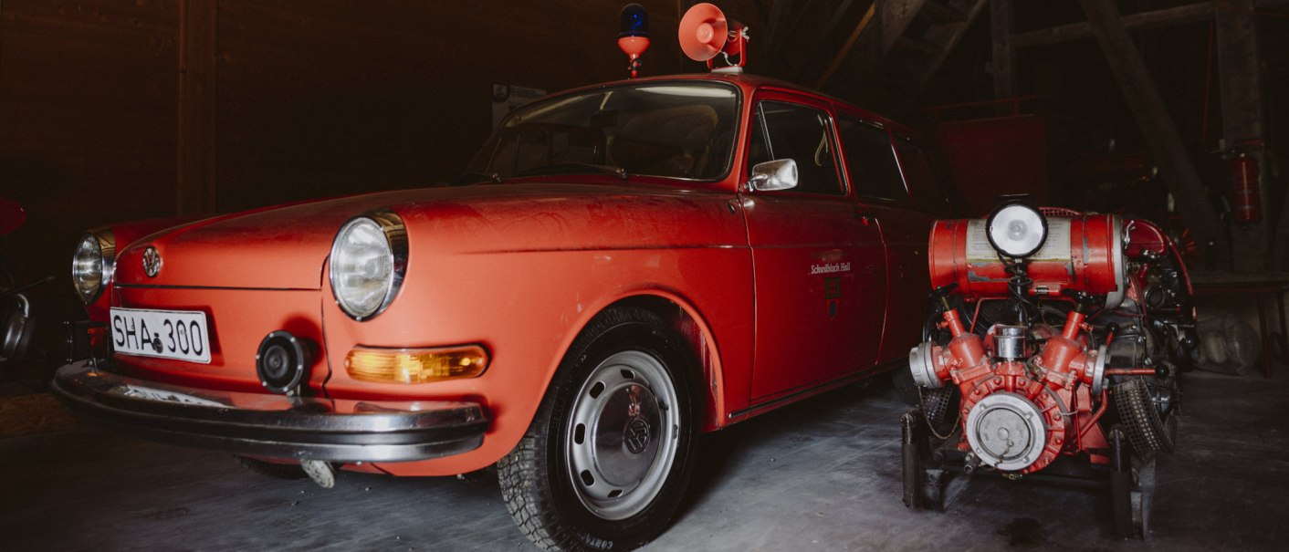 Rotes, historisches Feuerwehrfahrzeug mit Blaulicht und Sirene, daneben eine alte Feuerlöschpumpe im Feuerwehrmuseum Schwäbisch Hall., © Nico Kurth Rotes, historisches Feuerwehrfahrzeug mit Blaulicht und Sirene, daneben eine alte Feuerlöschpumpe im Feuerwehrmuseum Schwäbisch Hall., © Nico Kurth