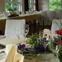 Festlich gedeckter Tisch im Römerhof Stuttgart mit Blumen, Kerzen und Gläsern, bereit für eine Veranstaltung., © Kulinarium und Römerhof Stuttgart
