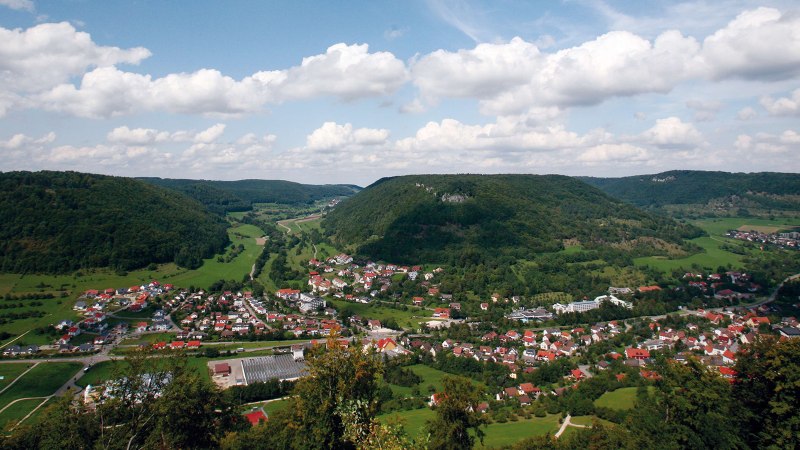 Panoramablick auf Bad Ditzenbach, umgeben von grünen Hügeln und Wäldern unter einem bewölkten Himmel., © Stuttgart-Marketing GmbH Panoramablick auf Bad Ditzenbach, umgeben von grünen Hügeln und Wäldern unter einem bewölkten Himmel., © Stuttgart-Marketing GmbH