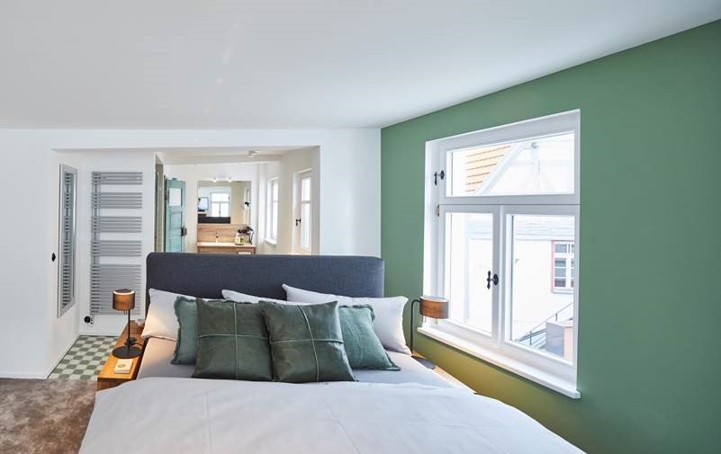 Modernes Schlafzimmer mit grün gestrichener Wand, großem Bett und Blick ins Badezimmer. Helle Fenster und stilvolle Einrichtung., © Hotel Restaurant Bachofer Modernes Schlafzimmer mit grün gestrichener Wand, großem Bett und Blick ins Badezimmer. Helle Fenster und stilvolle Einrichtung., © Hotel Restaurant Bachofer