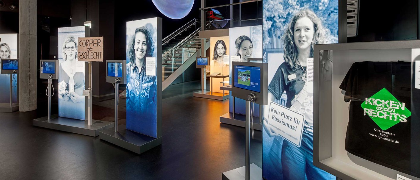 Eine Ausstellung mit großen Fotos, interaktiven Bildschirmen und Schildern zu sozialen Themen wie Rassismus und Geschlechtergleichheit., © Haus der Geschichte Baden-Württemberg, Daniel Stauch Photography Eine Ausstellung mit großen Fotos, interaktiven Bildschirmen und Schildern zu sozialen Themen wie Rassismus und Geschlechtergleichheit., © Haus der Geschichte Baden-Württemberg, Daniel Stauch Photography