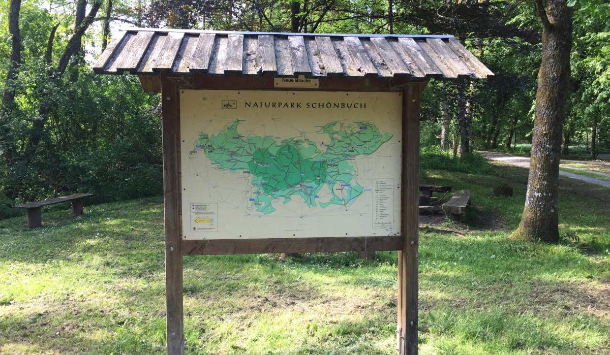 Ein hölzernes Schild mit einer Karte des Naturparks Schönbuch steht im Grünen, umgeben von Bäumen und einem Weg im Hintergrund., © www.pro-cycl.de Ein hölzernes Schild mit einer Karte des Naturparks Schönbuch steht im Grünen, umgeben von Bäumen und einem Weg im Hintergrund., © www.pro-cycl.de