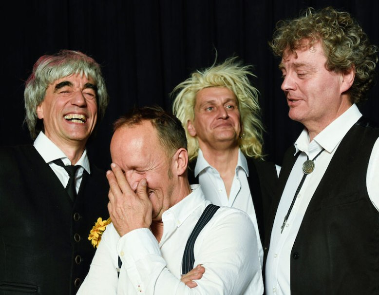 Vier Männer in Anzügen lachen herzlich. Einer hält sich die Hand vors Gesicht, während die anderen fröhlich in die Kamera schauen., © Veranstaltungsring Metzingen e.V. Vier Männer in Anzügen lachen herzlich. Einer hält sich die Hand vors Gesicht, während die anderen fröhlich in die Kamera schauen., © Veranstaltungsring Metzingen e.V.