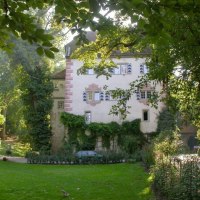 Burg Schaubeck inmitten eines grünen Gartens, umgeben von Bäumen. Die Fassade ist mit Efeu bewachsen, und Sonnenlicht fällt durch die Blätter., © Stuttgart Marketing Burg Schaubeck inmitten eines grünen Gartens, umgeben von Bäumen. Die Fassade ist mit Efeu bewachsen, und Sonnenlicht fällt durch die Blätter., © Stuttgart Marketing