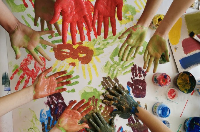 Kinderh&auml;nde, bemalt mit bunten Farben, &uuml;ber einem Blatt mit farbigen Handabdr&uuml;cken. Kreatives Malen f&uuml;r Kinder., &copy; Kunsthalle G&ouml;ppingen