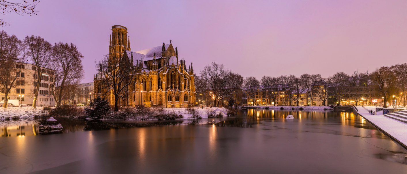 Die Johanneskirche am Feuersee in winterlicher Abendstimmung, umgeben von Schnee und beleuchtetem Wasser., &copy; Werner Dietrich