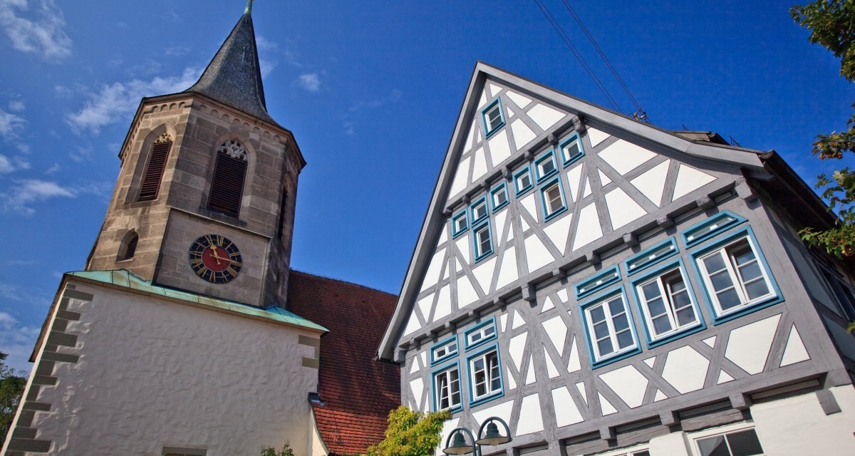 Die Evangelische Kirche Waiblingen-Neustadt neben einem Fachwerkhaus unter blauem Himmel., © Waiblingen - Stuttgart-Marketing GmbH Die Evangelische Kirche Waiblingen-Neustadt neben einem Fachwerkhaus unter blauem Himmel., © Waiblingen - Stuttgart-Marketing GmbH