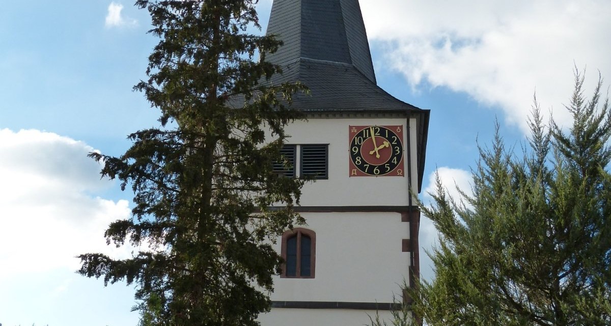 Die Martinskirche Döffingen mit ihrem markanten Turm und der Uhr, umgeben von Bäumen und blauem Himmel., © Natur.Nah. Schönbuch & Heckengäu Die Martinskirche Döffingen mit ihrem markanten Turm und der Uhr, umgeben von Bäumen und blauem Himmel., © Natur.Nah. Schönbuch & Heckengäu