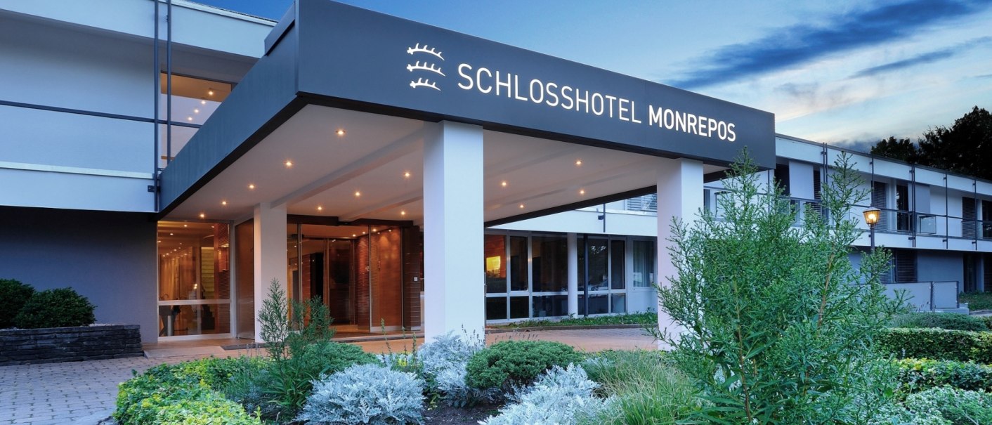 Eingangsbereich des Schlosshotel Monrepos mit modernem Vordach, beleuchtetem Eingang und gepflegtem Garten im Vordergrund., © Schlosshotel Monrepos Eingangsbereich des Schlosshotel Monrepos mit modernem Vordach, beleuchtetem Eingang und gepflegtem Garten im Vordergrund., © Schlosshotel Monrepos