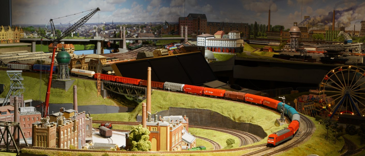 Detailreiche Modelleisenbahnlandschaft mit Zügen, Gebäuden und einem Riesenrad. Die Szene zeigt eine lebendige Miniaturwelt mit Industrie- und Stadtlandschaften., © PMW Winnenden e.V. Detailreiche Modelleisenbahnlandschaft mit Zügen, Gebäuden und einem Riesenrad. Die Szene zeigt eine lebendige Miniaturwelt mit Industrie- und Stadtlandschaften., © PMW Winnenden e.V.