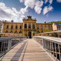 Historisches Gebäude in Bad Wildbad, Deutschland, mit einer Holzbrücke im Vordergrund und blauem Himmel im Hintergrund., © Touristik Bad Wildbad Historisches Gebäude in Bad Wildbad, Deutschland, mit einer Holzbrücke im Vordergrund und blauem Himmel im Hintergrund., © Touristik Bad Wildbad