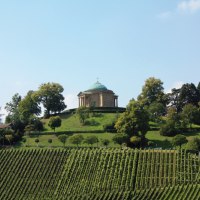 Die Grabkapelle auf dem Württemberg thront auf einem Hügel, umgeben von grünen Weinbergen und Bäumen unter einem blauen Himmel., © Stuttgart-Marketing GmbH